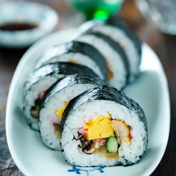 Sushi Hiro's maki sushi rolls, filled with egg, cucumber, and other ingredients, on a white plate.